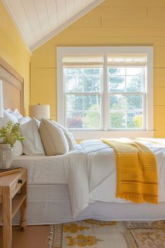 a bedroom with yellow walls and white bedding