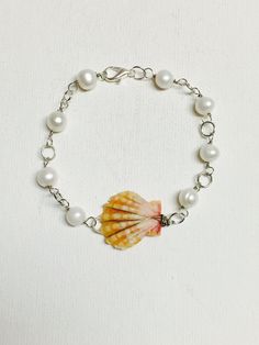 Hawaii sunrise shell silver plated wire wrapped link bracelet with white freshwater pearls. This one is 7 inches in length but one can be made in your size please specify size upon check out. Each shell is unique. Individual orders may vary slightly in appearance. A great gift for a loved one! Silver Pearl Shell For Beach, Beach Silver Pearl Shell, Sunrise Shell, Hand Chain Jewelry, White Freshwater Pearl, Hand Chain, Chain Jewelry, Beach Jewelry, Chain Link Bracelet