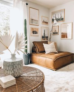 a living room filled with furniture and pictures hanging on the wall above a coffee table