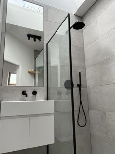 a bathroom with a sink, mirror and shower head in the middle of the room