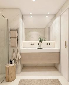 a large bathroom with two sinks and a shower in the corner, along with a rug on the floor