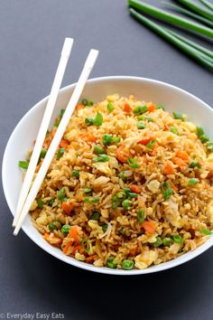 rice and vegetables in a bowl with chopsticks