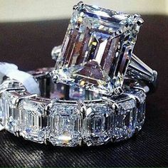 an engagement ring and wedding band are shown on a table