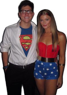 a man standing next to a woman wearing a superman shirt and short shorts with her arms around her waist