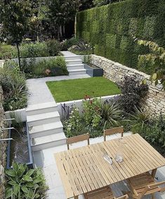 a wooden table sitting in the middle of a garden