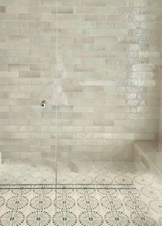 a white tiled shower with a glass door