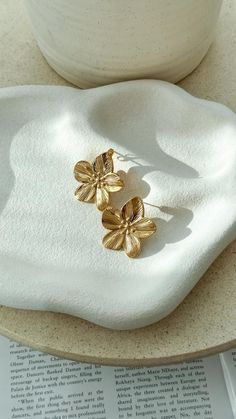 Enhance your look with these gold-plated flower earrings. Featuring a textured flower design, these studs are perfect for adding a touch of elegance to any outfit. L: 3cm W: 3cm. Earring Product Photography, Earrings Photography Ideas, Jewellery Photography Inspiration, Earrings Outfit, Jewelry Product Shots, Flower Earrings Gold, Creative Jewelry Photography, Jewelry Photography Styling, Tiffany Earrings