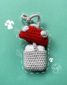 a crocheted keychain with a red and white object hanging from it