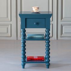 a small blue table with a cup on top