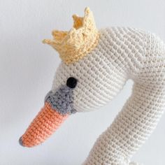 a crocheted white bird with a yellow crown on it's head and neck