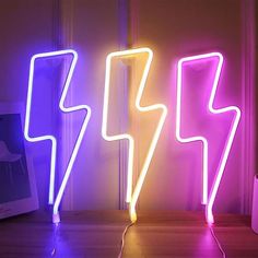 two neon lights sitting on top of a wooden floor