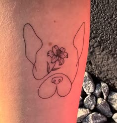 a tattoo on the leg of a woman with flowers in her hair and an image of a pig