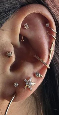 a woman wearing multiple ear piercings with different designs