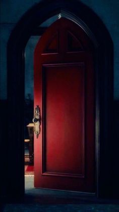 an open red door with a clock on it