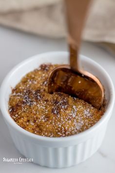 a small white bowl filled with food on top of a table