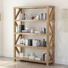 a wooden shelf with books on it in a room next to a white wall and hardwood floor