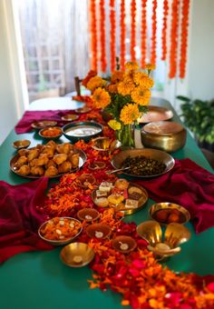 the table is set up with many different foods and flowers in vases on it