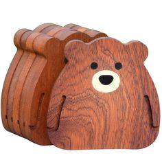 a wooden toy bear sitting on top of a piece of wood