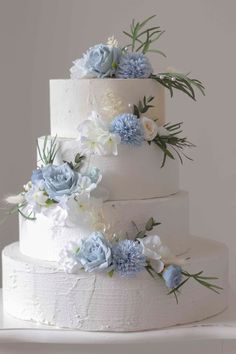 a wedding cake with blue and white flowers on top