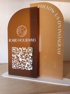 a wooden table topped with a sign and qr code on it's side