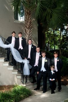 a group of young men standing next to each other in front of a stair case