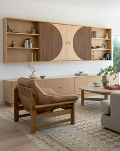 a living room filled with furniture next to a wall mounted bookcase and window sill