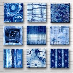 six blue paintings on a white brick wall