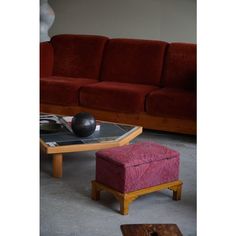 a living room filled with furniture and a coffee table in front of a red couch