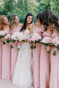 the bride and her bridesmaids are all wearing pink dresses with white bouquets