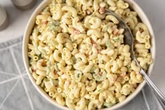 a white bowl filled with macaroni and cheese on top of a gray table