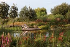 there is a boat that is sitting in the water near some trees and flowers on the shore