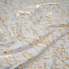 a white and gold table cloth with golden streaks on it