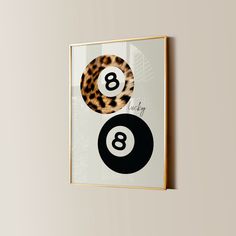 an animal print is hanging on the wall next to a pair of black and white pool balls