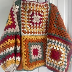 a crocheted sweater hanging on a hook