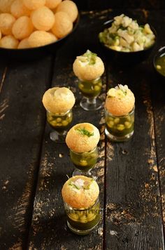 several small cups filled with food on top of a wooden table