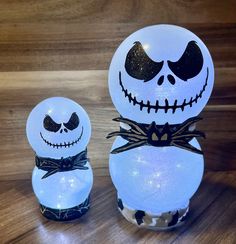 two lighted jack skellings are sitting next to each other on a wooden surface