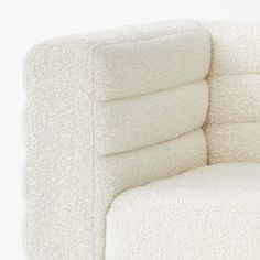 a close up of a white chair with pillows on it's back and arms