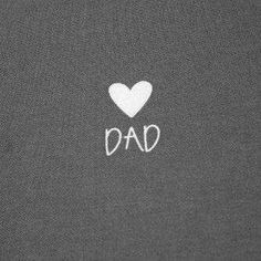 the word dad written in white on a dark gray background with a heart and two small white hearts