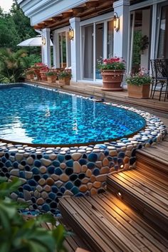 a small pool with blue and white pebbles in the water, surrounded by wooden steps