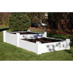 a white raised garden bed sitting in the grass