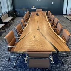 an empty conference room with chairs and a large wooden table in the middle of it