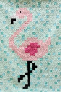 a pink flamingo quilted on top of a bed