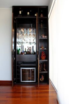 an empty room with a bar in the corner and wood flooring on the other side