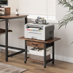 a computer desk with a printer on top of it