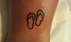 a small tattoo on the ankle of a person with flip flops painted on it