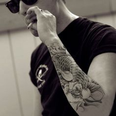 a man with tattoos on his arm is talking on a cell phone while wearing sunglasses