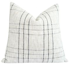 a white and black plaid pillow on a white background