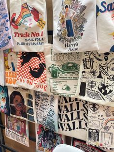 many t - shirts are hanging up on the wall in front of a bowl and cup