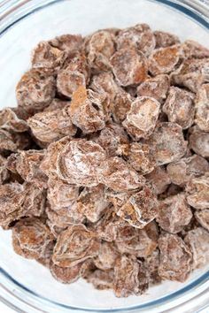 a glass bowl filled with lots of brown sugary treats on top of a table