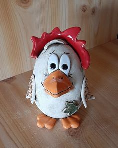 a ceramic chicken sitting on top of a wooden table